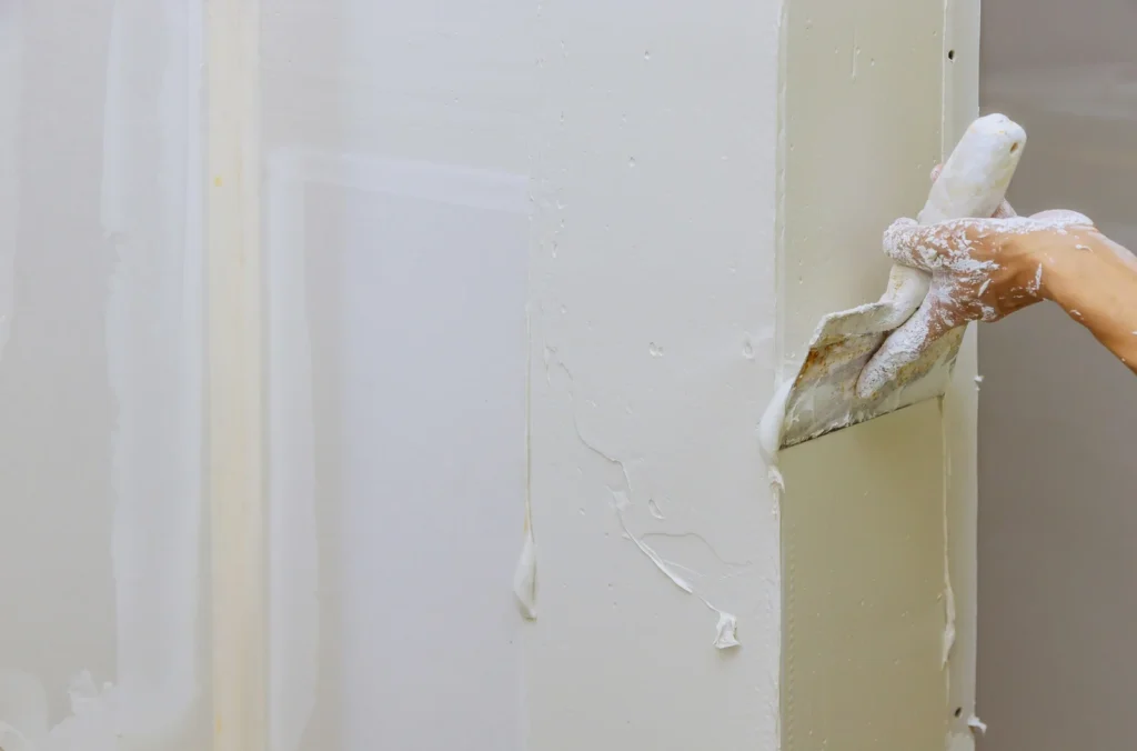 um-trabalhador-usando-gesso-para-revestir-paredes-de-gesso-construção