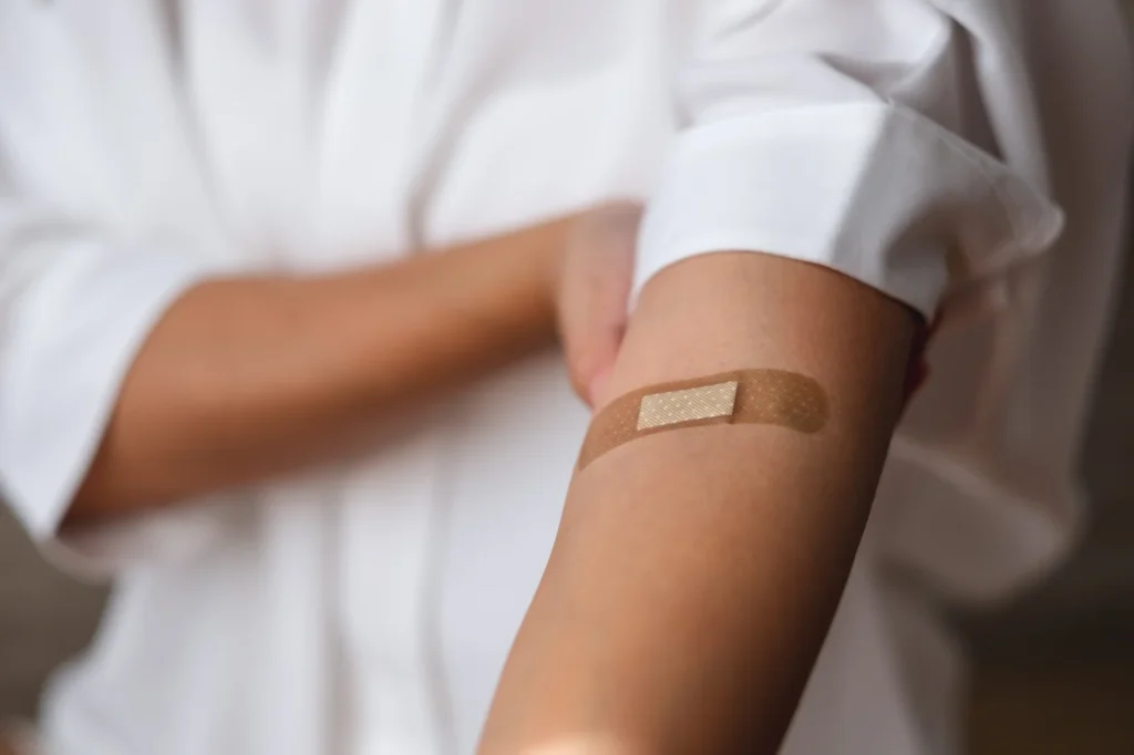 uma-mulher-com-bandagem-adesiva-médica-gesso-band-aid-no-braço